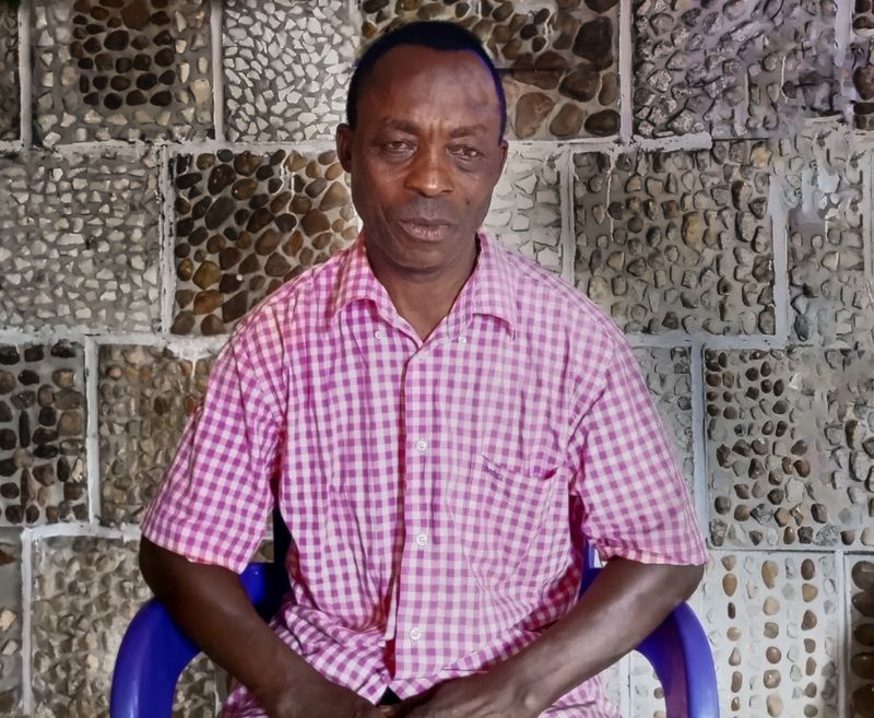 Cameroonian man making African tiles out of stones 3 big